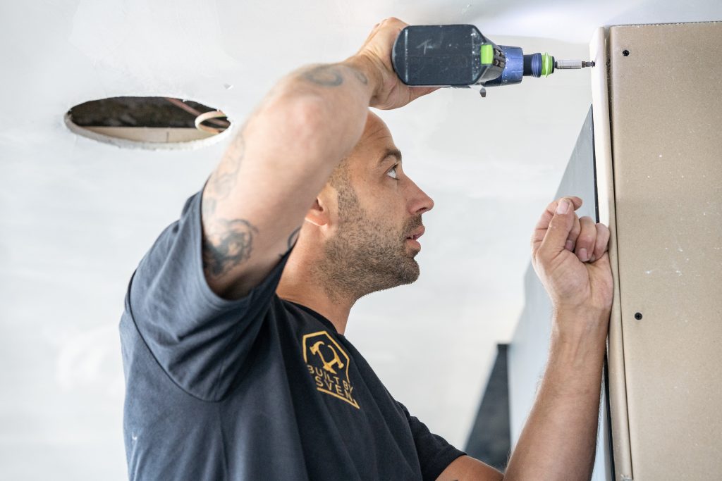 Vakman boort een bevestiging in de wand