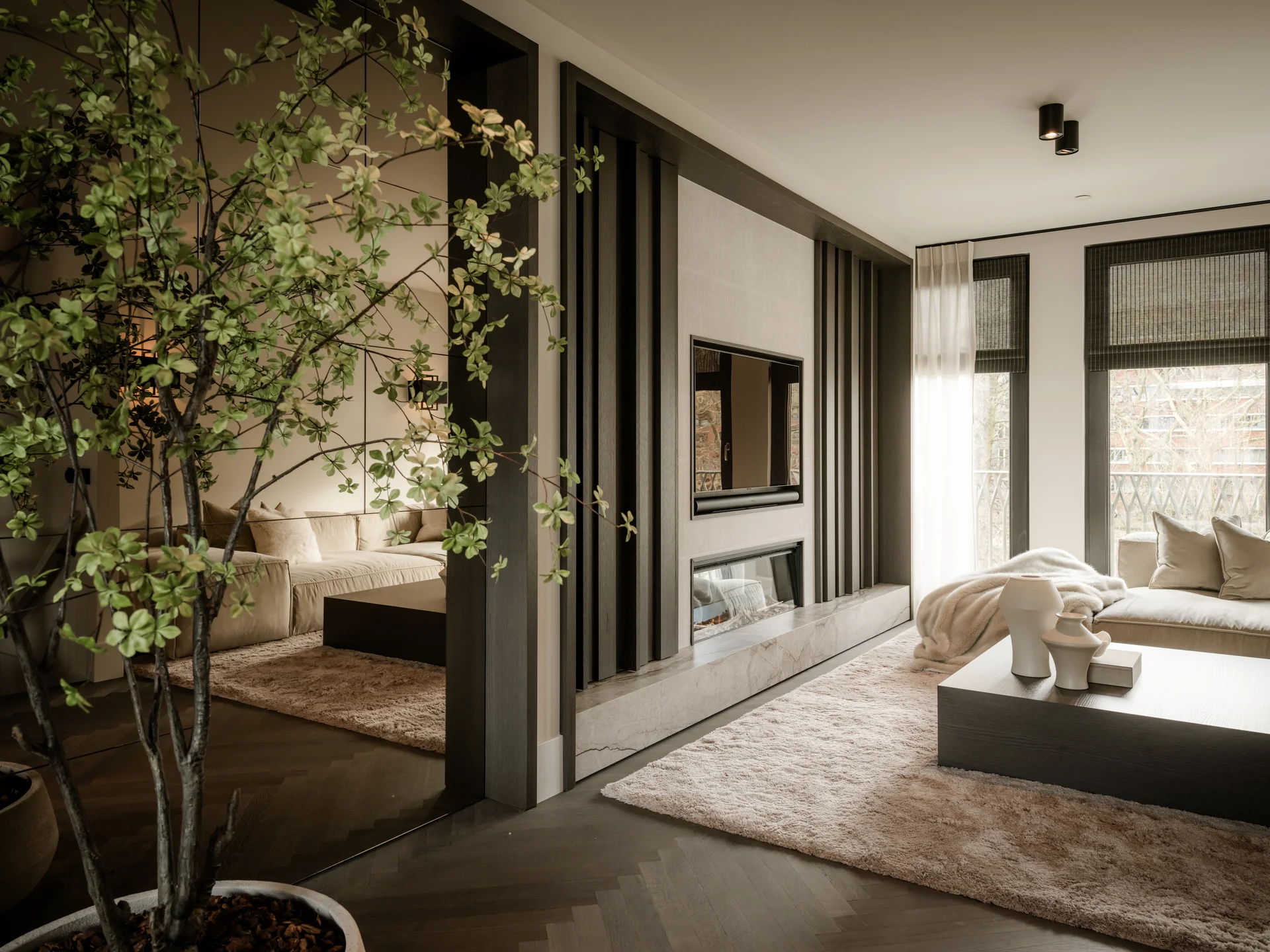 Afgewerkte woonkamer met haard en wandafwerking