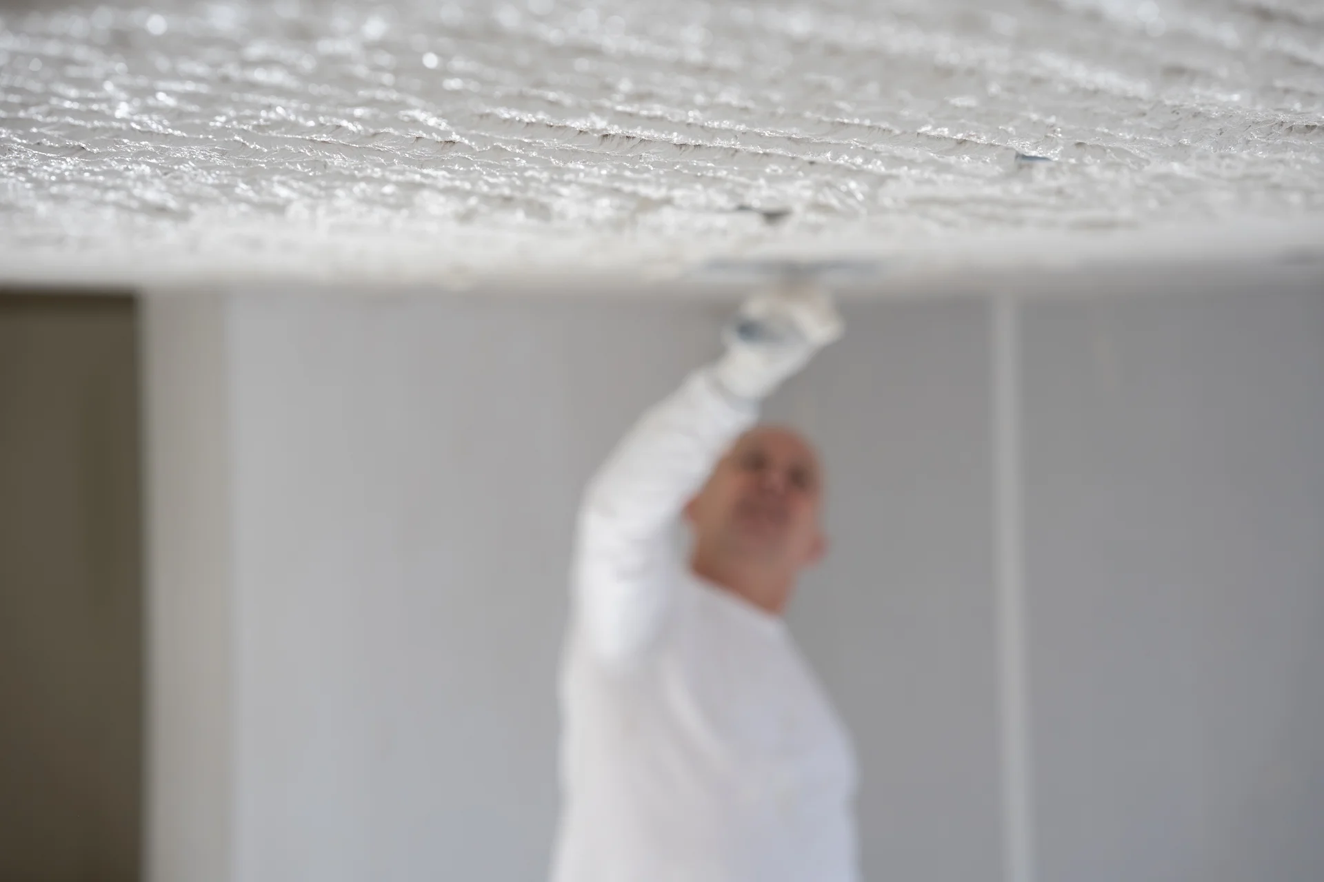 Stukadoor strijkt een plafond glad